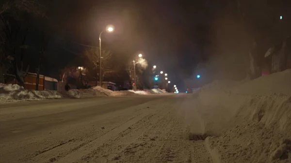 Time-lapse strzelanie rosyjskiej zimowej drogi w godzinach wieczornych. Para wypływa z kratki ściekowej na drodze. — Zdjęcie stockowe