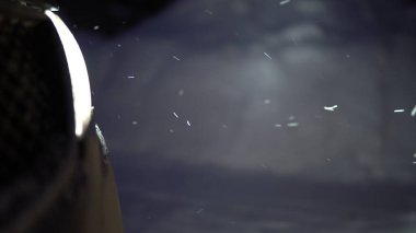 Araba farları akşam düşen karı aydınlatıyor.