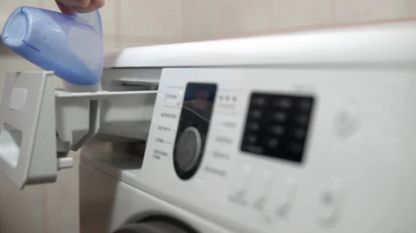 Meisje laadt waspoeder in de wasmachine close-up — Stockfoto