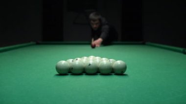 Beyaz bilardo topu piramidini kıran bir adam. Rus bilardosu oynamaya başla.