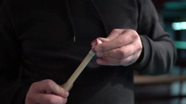 Bir adam vurmadan önce bilardo ıstakasının ucunu tebeşirle ovar. Bilardo oynamaya hazırlanıyor