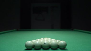 Beyaz bilardo topu piramidini kırmak üzere olan bir adam. Bilardo oyununun başlangıcı.