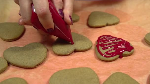 Декорація печива у вигляді серця з червоним солодким глазур'ям. Печиво для Валентинів — стокове відео