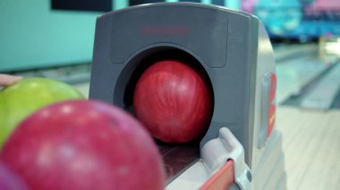 Bowling topu iade sistemi yakın plan. Kız bir bowling topu alır 4K