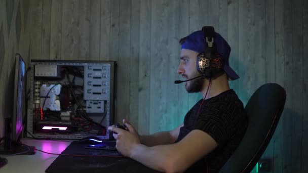 Ο τύπος παίζει προσεκτικά παιχνίδια στον υπολογιστή με ένα χειριστήριο — Αρχείο Βίντεο