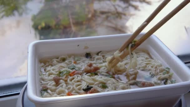 Ανακατέψτε τα noodles με κινέζικα chopsticks στην κορυφή του ράμεν. Στιγμιαίες χυλοπίτες — Αρχείο Βίντεο