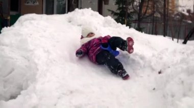 Bir kız Rus bahçesinde kar kaydırağına biniyor. Ağır çekimde çekmek