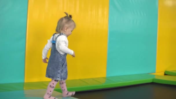놀이터에서 트램펄린을 타고 달리는 어린 소녀 — 비디오