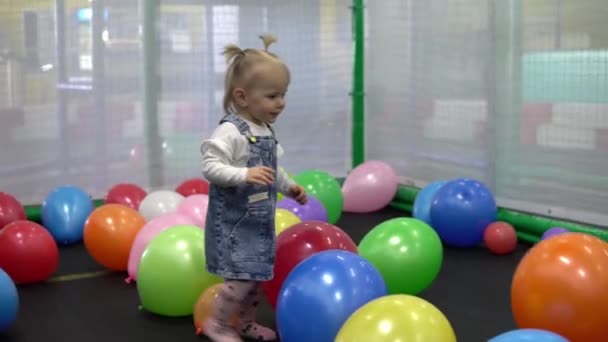 Meisje spelen met kleurrijke ballonnen in de speeltuin — Stockvideo