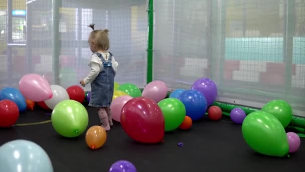 Meisje spelen met kleurrijke ballonnen in de speeltuin — Stockvideo