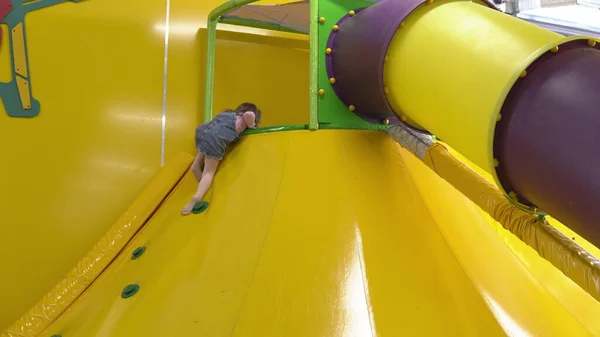 A menina no playground sobe o slide — Fotografia de Stock