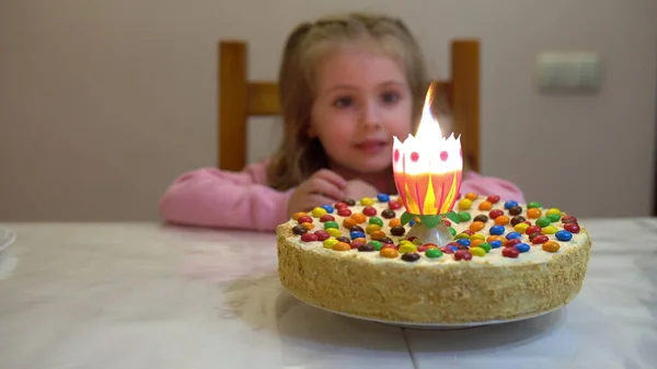 Dziewczyna ma urodziny. Zapal świece na torcie. — Zdjęcie stockowe
