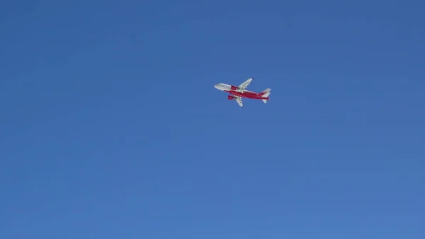 Un aereo decolla dietro gli alberi in inverno. L'aereo sta guadagnando quota nel cielo. L'iscrizione sull'aereo Russia — Foto Stock