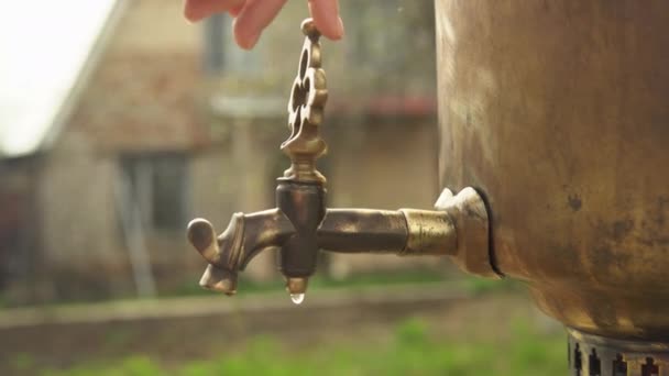 Una mano femminile apre il rubinetto in ottone del samovar e l'acqua bollente scorre — Video Stock