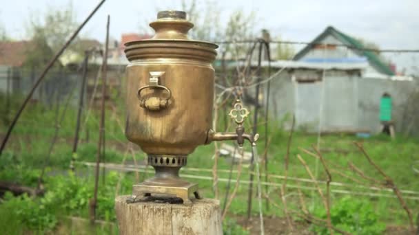 Er stroomt kokend water uit een oude koperen samovar. Thee zetten in een samovar — Stockvideo