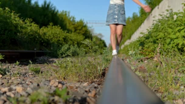 Primer plano de una chica caminando sobre los rieles. Camina por las vías del ferrocarril. Vía férrea — Vídeos de Stock