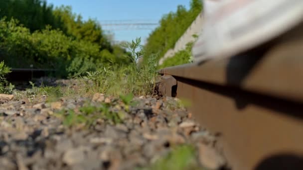 Primer plano de una chica caminando sobre los rieles. Camina por las vías del ferrocarril. Vía férrea — Vídeo de stock