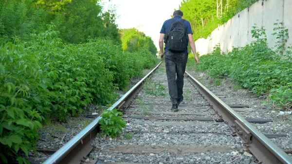 Sırt çantalı bir adam yataklı vagonda yürüyor. Demiryolu raylarında seyahat et. Eski tren yolu — Stok fotoğraf