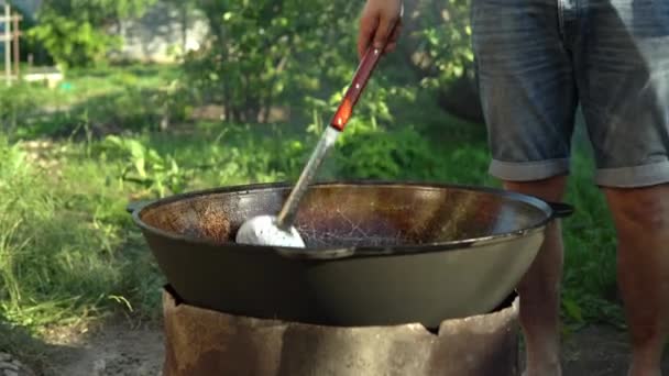 Cucinare cibo su un fuoco in un calderone. Cucina all'aperto. 4k — Video Stock