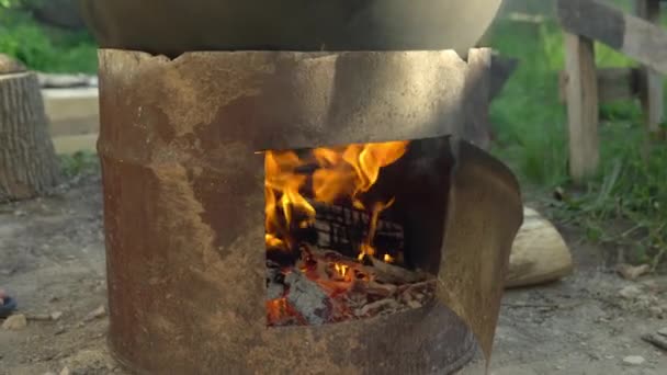 Bränner eld för att värma upp pannan. Matlagning över elden. Utomhusmatlagning 4k — Stockvideo