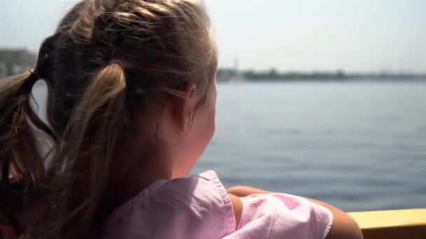 La chica a bordo del ferry en la perrilla mira hacia la inmensidad del río. Paseo en barco por el río 4k — Vídeos de Stock