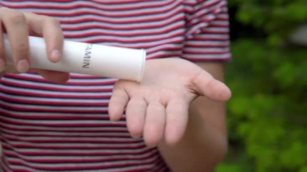 La jeune fille tient une capsule dans sa main et en tire des vitamines dans la paume de sa main. Maintien de l'immunité. Mode de vie sain. 4k — Video
