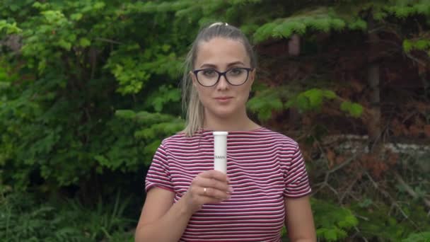 眼鏡をかけた女の子が手にカプセルを持ち、ビタミンを取り出します。免疫を維持する。健康的なライフスタイル。4k — ストック動画