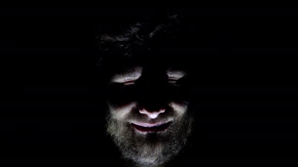 Ciri-ciri pria, wajah berjenggot, latar belakang dalam gelap. Menutup wajah seorang pria dalam gelap yang tersenyum — Stok Video