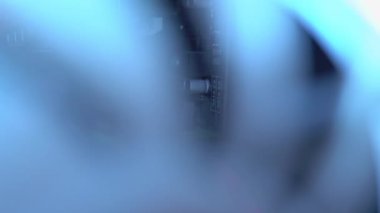 Bilgisayar davasındaki vantilatörün mavi ışığı. Mavi bıçaklar havalı bilgisayar parçalarına dönüşür. Oyun bilgisayarı karanlıkta parlıyor