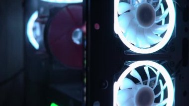 Bilgisayar davasındaki vantilatörün mavi ışığı. Mavi bıçaklar havalı bilgisayar parçalarına dönüşür. Oyun PD 'si karanlıkta parlıyor. Bilgisayarın tozlu yan camı