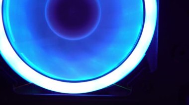 Bilgisayar davasındaki vantilatörün mavi ışığı. Mavi bıçaklar havalı bilgisayar parçalarına dönüşür. Oyun bilgisayarı karanlıkta parlıyor