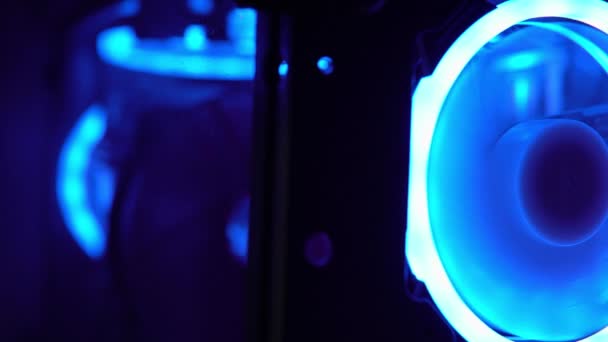 Синя підсвічування вентилятора в корпусі ПК. Сині лопаті обертаються для охолодження комп'ютерних компонентів. Ігровий комп'ютер світиться в темряві — стокове відео