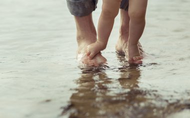 Çıplak ayak baba ve küçük oğlu yansıtan suda kalıyorum