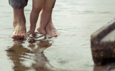 Çıplak ayak baba ve küçük oğlu yansıtan suda kalıyorum