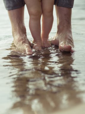 Çıplak ayak baba ve küçük oğlu yansıtan suda kalıyorum