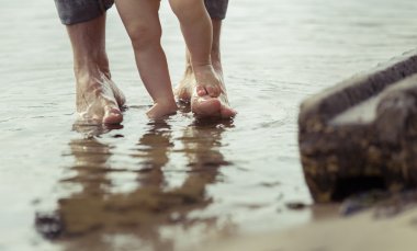 Çıplak ayak baba ve küçük oğlu yansıtan suda kalıyorum