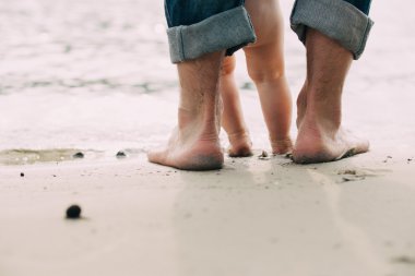 Çıplak ayak baba ve küçük oğlu kum suya yakın kalmak