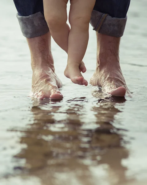 Bare feet father and his little son staying in the reflecting water — Stock Photo, Image