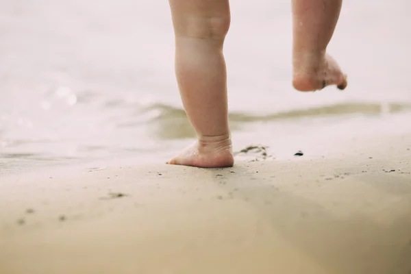 Kleinkind macht seine ersten Schritte im Sand am Ufer — Stockfoto