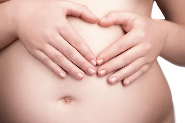 Belly of pregnant woman doing heart sign with her hands — Stock Photo, Image