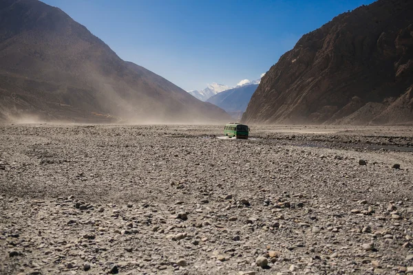 Одинокий автобус пытается добраться до места назначения. Трудности с дорогой. Живописный вид на дорогу к горе Аннапурна в Непале. Треккинг в Аннапурне — стоковое фото