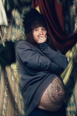 Güzel hamile kadın üzerinde dramatik poz karnında kına desenli