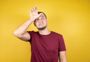 Rus adam sarı arka plan üzerine kırmızı tişört giyiyor. Alnında parmakları olan insanlarla alay ediyor. Ezik hareketler yapıyor, alay ediyor ve hakaret ediyor..