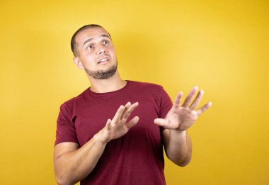 Rus adam, sarı tişört giyiyordu. Korkarak ve korkarak korku ifadesinden korkmuştu. El hareketlerini durdur, şok içinde bağır. Panik konsepti.