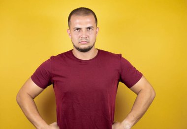 Rus adam, sarı tişörtlü, titiz, kuşkucu ve gergin. Yüzünde, kolları belinde, tasvip etmeyen bir ifade var.