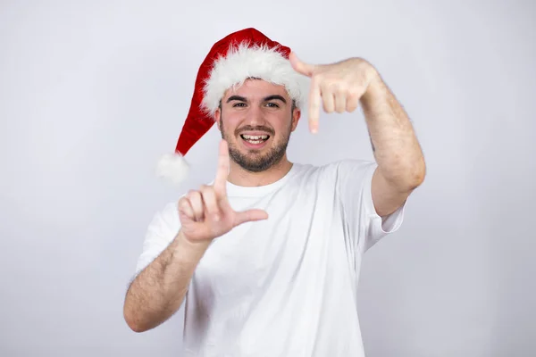 Jonge Knappe Man Draagt Een Santa Hoed Witte Achtergrond Glimlachend — Stockfoto