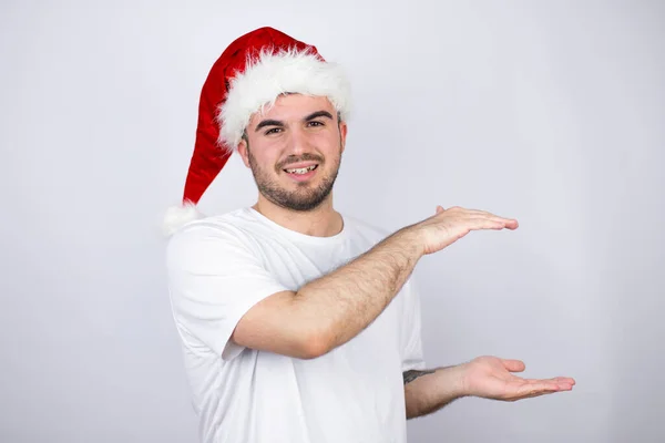 Jonge Knappe Man Draagt Een Kerstman Hoed Witte Achtergrond Gebaren — Stockfoto