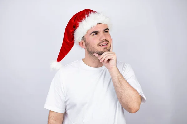 Mladý Pohledný Muž Klobouku Santa Přes Bílé Pozadí Myšlení Při — Stock fotografie