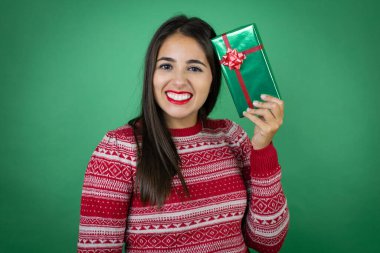 Genç, güzel bir kız, soyutlanmış beyaz arka planda hediyesini tutuyor.