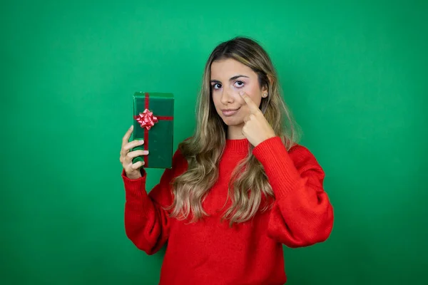 Jovem Menina Bonita Segurando Presente Sobre Fundo Verde Isolado Apontando — Fotografia de Stock